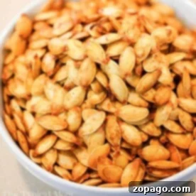Close-up of air fryer pumpkin seeds in a white bowl, perfectly roasted for a crunchy delight.