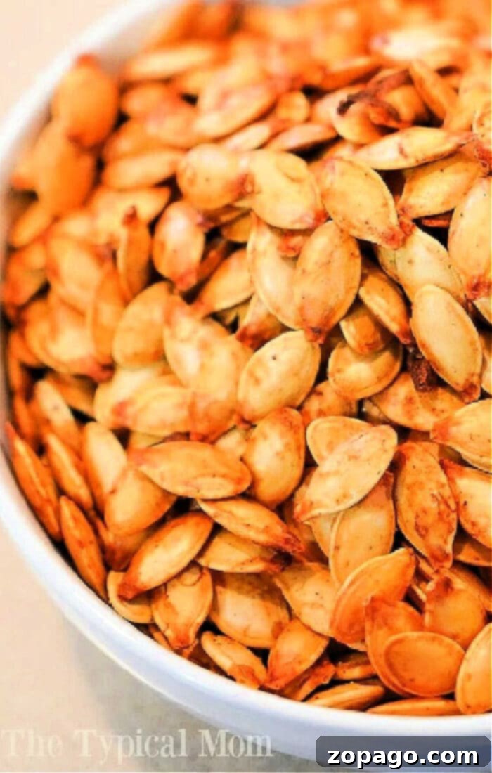 Crispy Air Fried Pumpkin Seeds 6 A close-up view of pumpkin seeds being air fried in a black air fryer basket, turning golden and crispy. This image perfectly captures the process of making air fryer pumpkin seeds.