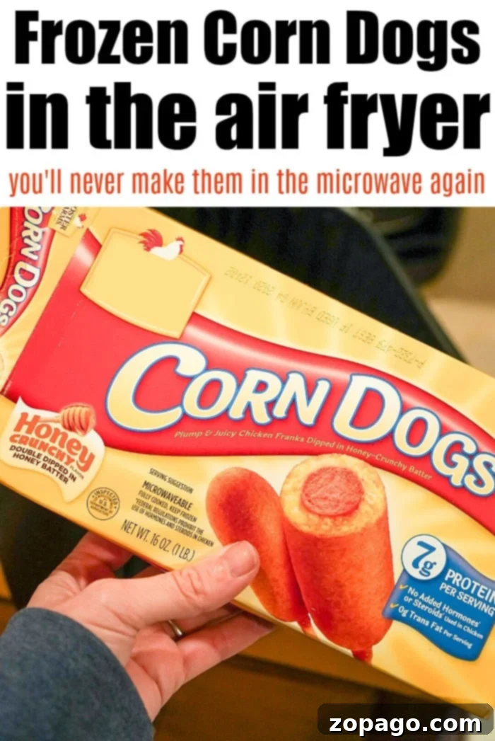 Crispy Corn Dogs: Air Fryer Method Three perfectly air-fried frozen corn dogs arranged neatly in an air fryer basket, showcasing their golden-brown color.