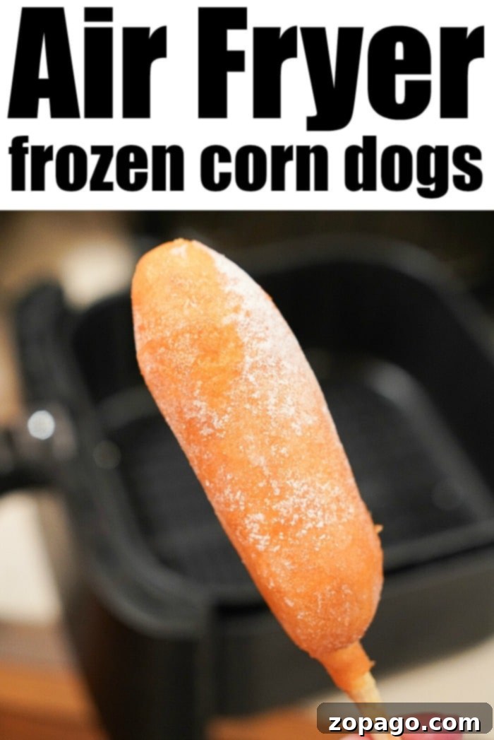 Close-up of a hand holding a perfectly crisped air fryer frozen corn dog, ready to be enjoyed, with the air fryer visible in the background.