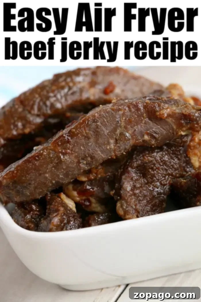 Best air fryer beef jerky is here! Ready to make tender beef in your Ninja Foodi or electric air fryer? We have an easy way to try your first batch. #airfryerbeefjerky #airfryer #airfryerrecipes #ninjafoodirecipes #foodi #ninjafoodi #thetypicalmom A close-up of a white bowl filled with pieces of dark brown beef jerky.