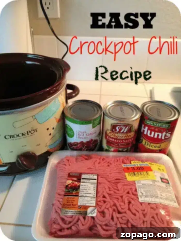 A photo showing ingredients for a 5 ingredient Crockpot chili recipe. Includes a Crockpot, a pack of minced meat, a can of tomato sauce, a can of diced tomatoes, and a can of dark red kidney beans. Text at the top reads 'EASY Crockpot Chili Recipe.'