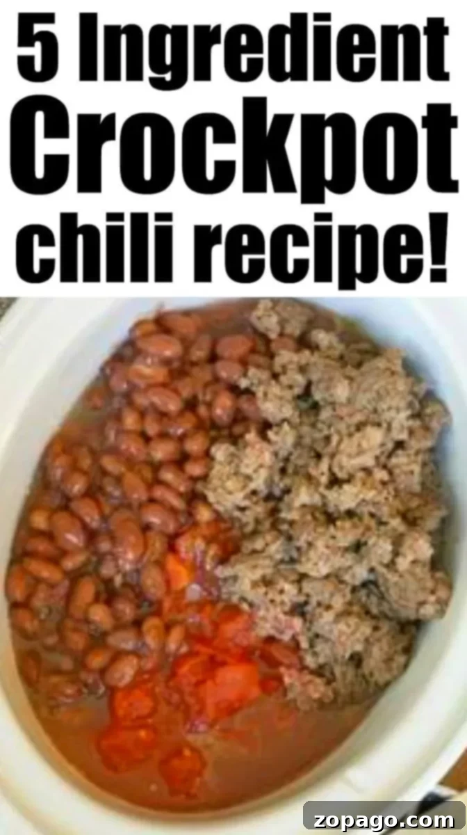 A white crockpot containing a chili mixture with beans, ground meat, and diced tomatoes.