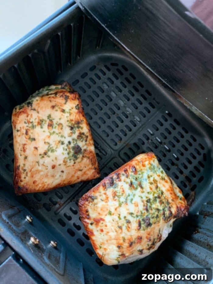 Perfect Air Fried Pork 6 Two seasoned pork fillets in an air fryer basket, ready to be cooked to perfection.