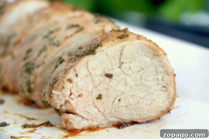 Perfect Air Fried Pork 9 A perfectly cooked slice of air fryer pork loin on a cutting board