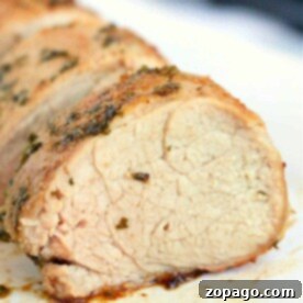 Close-up of sliced roasted pork loin, seasoned with herbs and cooked to perfection in an air fryer, showcasing a juicy and tender texture.