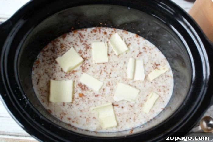 A top-down view of a Crockpot filled with rice pudding, showing its creamy texture and readiness as a dessert.