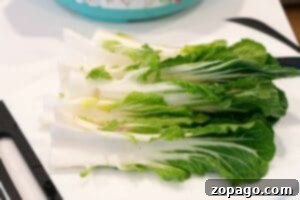 Perfect Instant Pot Bok Choy 5 Fresh bok choy, washed and halved, displayed on a white cutting board—perfect for learning how to make bok choy dishes at home.