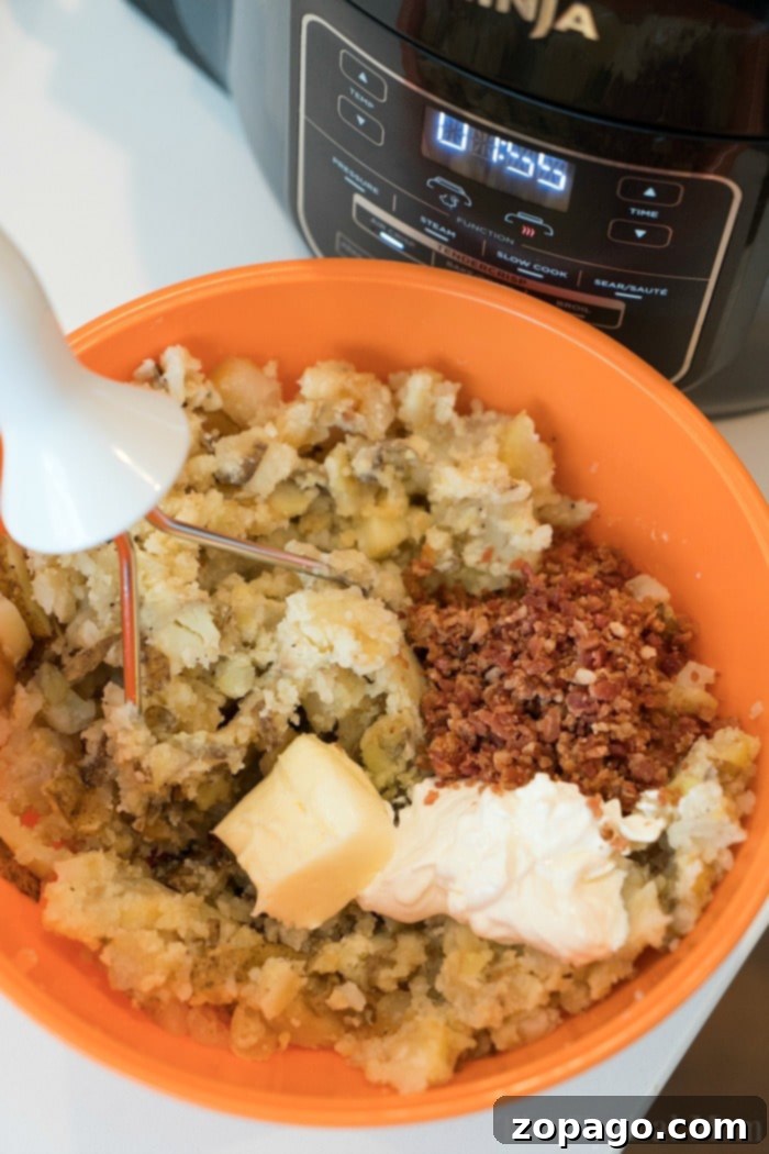 Ninja Foodi mashed potatoes comes out great, all in one pot! Tender pressure cooked meat and potatoes, then air fried steak with the best dry rub. #ninjafoodi #ninjafoodirecipes #foodi #steak #mashedpotatoes #onepotmeals #thetypicalmom Creamy pressure cooker mashed potatoes ready to be served.