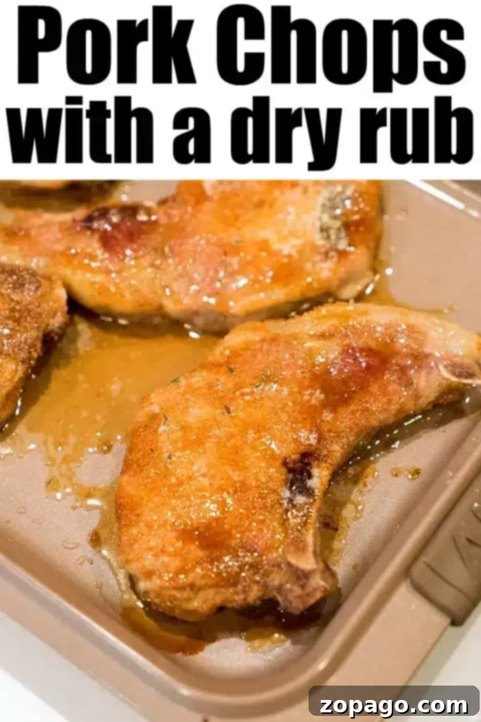 Flavorful Dry Rub Baked Pork Chops 9 The best baked pork chops are arranged on a baking tray, glistening with juices and coated in a flavorful dry rub, their golden-brown exterior promising a delightful culinary experience.