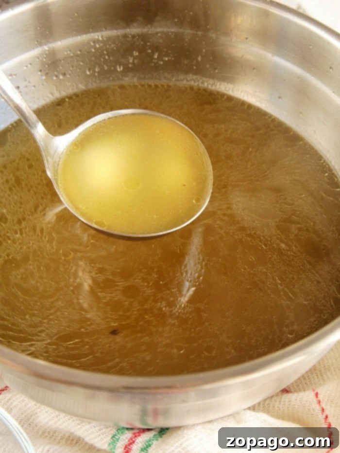 homemade broth in jars on a wooden surface