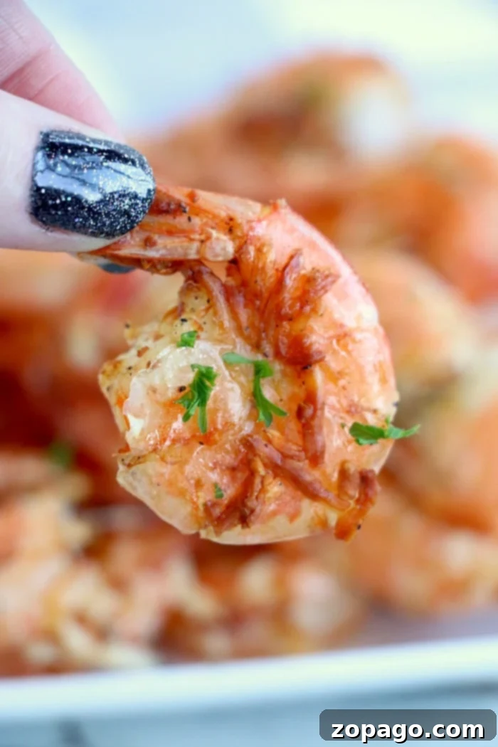 Crispy Air Fryer Frozen Shrimp 2 Perfectly cooked air fryer frozen shrimp with a vibrant pink hue, garnished with fresh herbs and ready to be served.