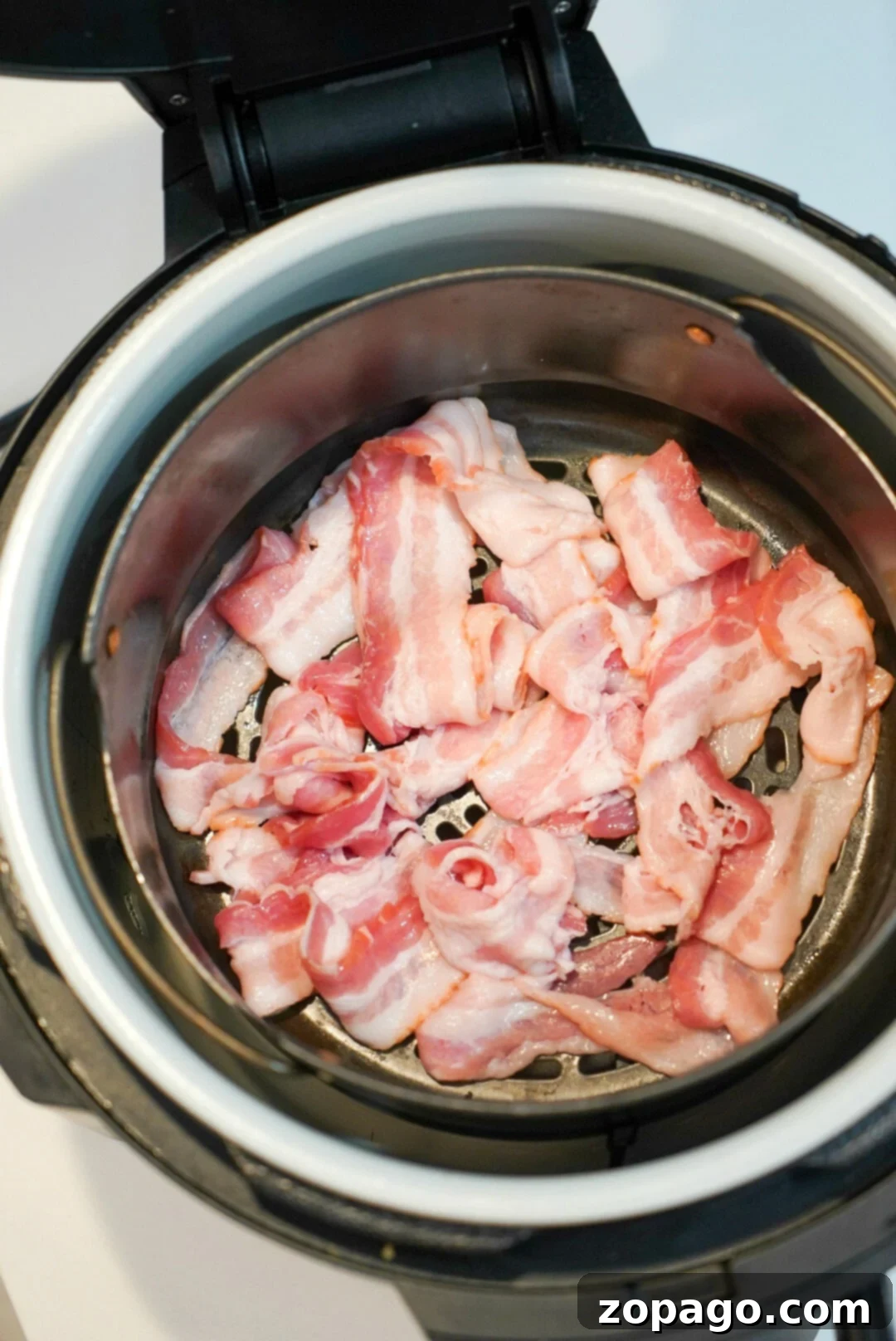 Bacon in air fryer is a game changer! Grease drips away and it get crispy in no time at all for breakfast. Try Ninja Foodi bacon this morning and see. #airfryerbacon #bacon #airfryerrecipes #ninjafoodi #foodi #thetypicalmom Ninja Foodi bacon cooked to a perfect crisp for breakfast.