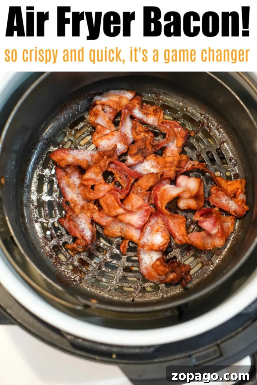 Bacon in the air fryer is a game changer! Grease drips away and it get crispy in no time at all for breakfast. Try Ninja Foodi bacon this morning and see. #airfryerbacon #bacon #airfryerrecipes #ninjafoodi #foodi #thetypicalmom Crispy bacon being removed from an air fryer basket, showing golden perfection.
