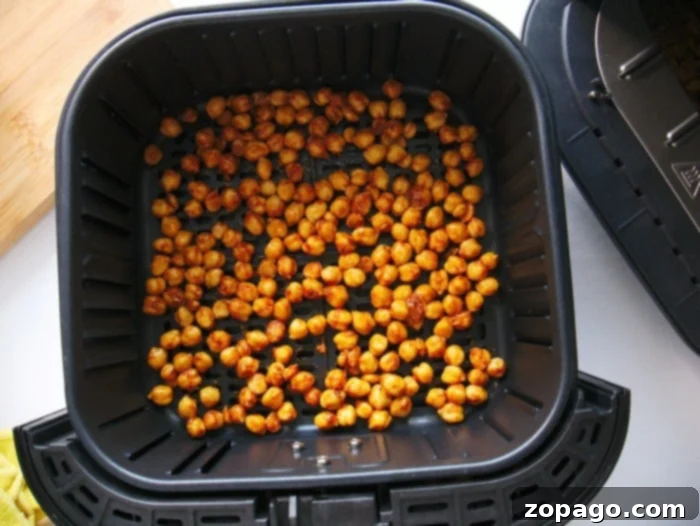 Crispy Air Fryer Chickpeas 5 A bowl of seasoned chickpeas, lightly coated in oil and spices, ready for air frying.