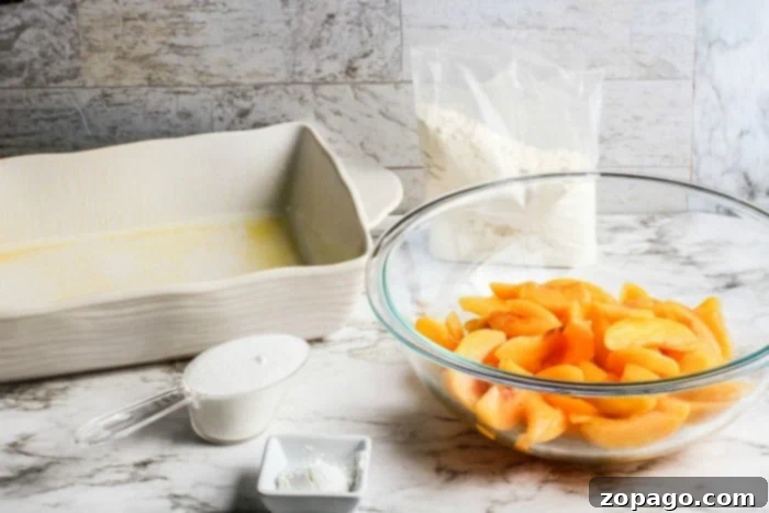 Juicy Fresh Peach Dump Cake with Cake Mix 3 The layering process of making peach dump cake, showing peaches spread in a baking dish.