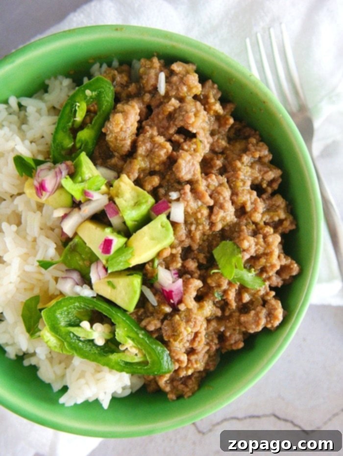 Instant Pot taco bowls with ground beef over rice are the bomb! Add cheese and all the fixings for a pressure cooker recipe even your kids will love. A vibrant Instant Pot taco bowl filled with seasoned ground beef, rice, fresh avocado slices, and shredded cheese.