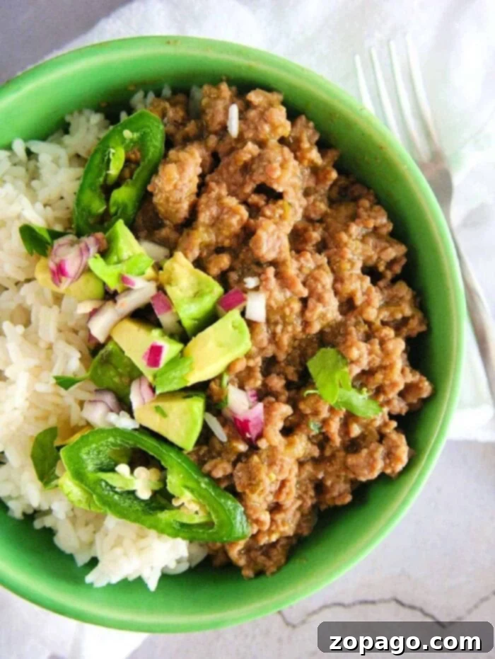 One-Pot Instant Pot Beef Taco Bowls 9 A top-down view of an Instant Pot ground beef taco bowl with rice, meat, and fresh toppings.