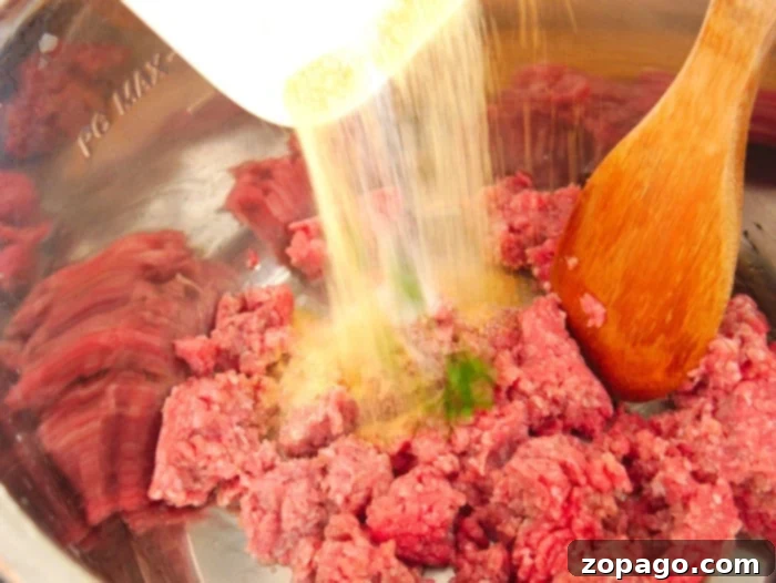One-Pot Instant Pot Beef Taco Bowls 4 Instant Pot ground beef with diced onions and seasonings, ready for taco bowls.