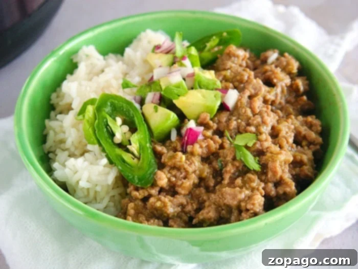 One-Pot Instant Pot Beef Taco Bowls 7 Three colorful taco bowls filled with seasoned ground beef, rice, and various fresh toppings.
