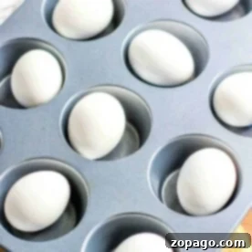 Eggs in a muffin tin on a yellow cloth, illustrating a simple and effective method for how to hard boil eggs in the oven.