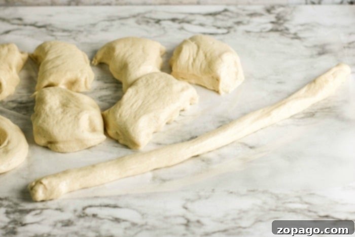 Soft Pretzels Made Simple 4 A batch of freshly twisted pretzel dough pieces on a floured surface, ready for the baking soda bath.