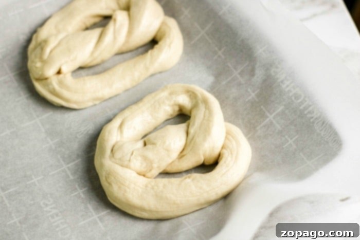 Soft Pretzels Made Simple 5 Freshly shaped pretzels boiling in a baking soda bath, soon to be transferred to a baking sheet.
