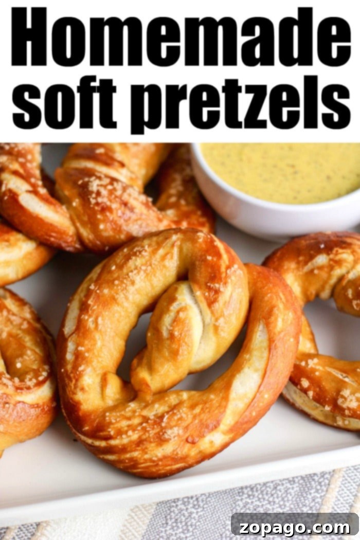 This easy soft pretzel recipe is fantastic! A copycat Auntie Anne's pretzels style snack, these large chewy and salty pretzels will make your mouth water. #pretzels Close-up of a stack of golden brown, homemade easy soft pretzels, garnished with coarse sea salt.