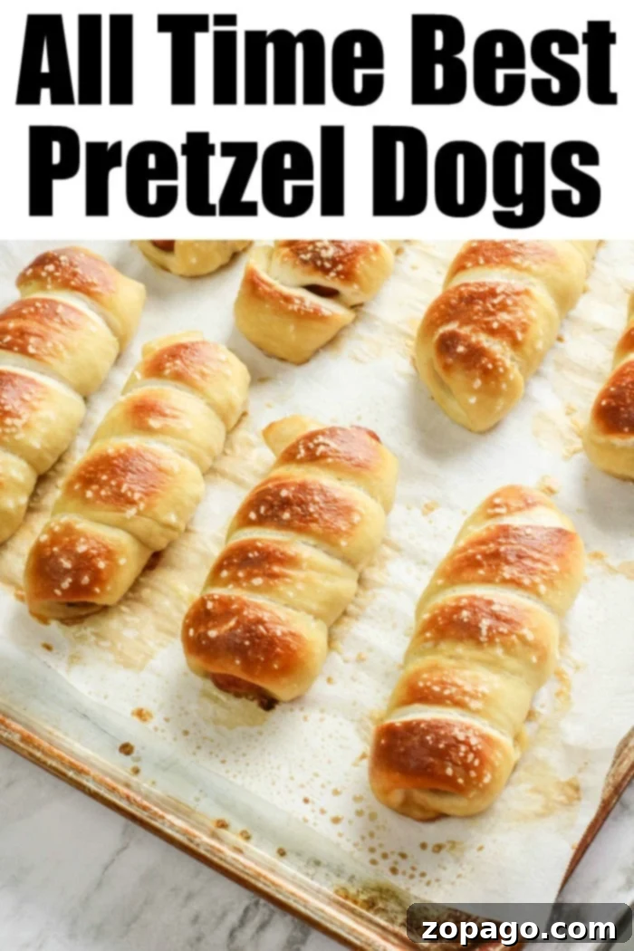 Copycat Auntie Anne's pretzel dogs are the bomb! If you love homemade soft pretzels and hot dogs for lunch this is going to become your go to recipe. #pretzeldogs #pretzels Close-up of freshly baked Pretzel Dogs on a wooden board