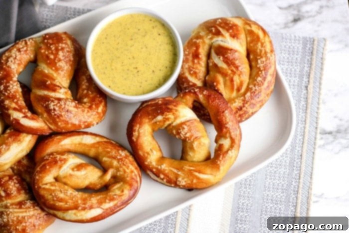 Twist and Dip Mustard 4 Assortment of soft pretzels and pretzel sticks artfully arranged around a bowl of homemade pretzel dipping sauce.