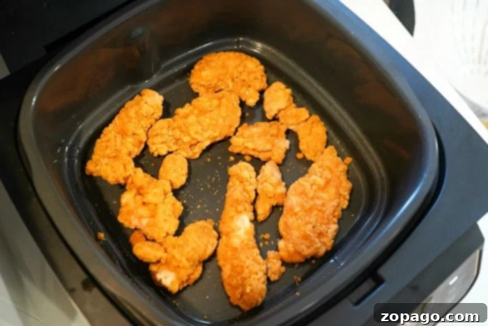 Crispy Air Fryer Frozen Chicken Tenders 2 A serving of crispy breaded frozen chicken strips, perfectly cooked in an air fryer, arranged artfully for a delicious meal.