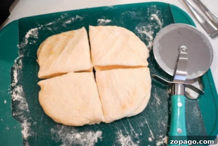 Crispy Air-Fried Tortillas 8 Homemade flour tortilla recipe in its simplicity, is cut into four pieces on a green cutting board, with a pizza cutter resting beside it.