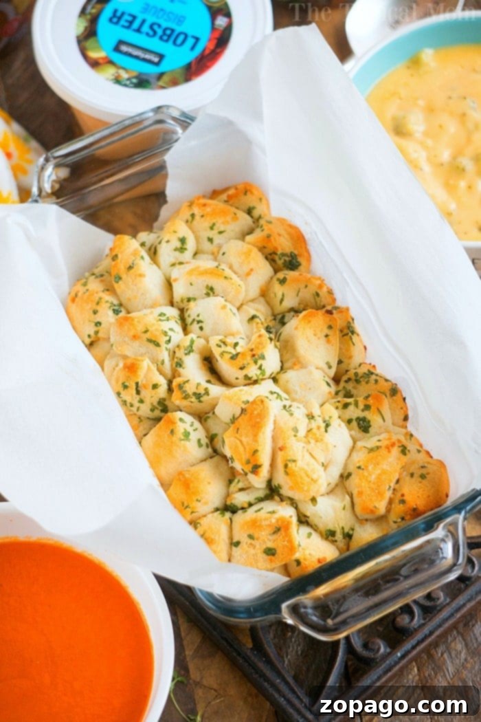 Homemade Yeast Bread from Scratch 12 Delicious garlic pull-apart bread, golden brown and garnished with fresh herbs, ready to be served.
