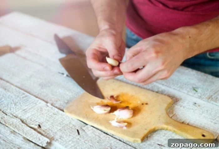 Mincing Garlic Cloves 4 A chef's knife mincing garlic cloves on a cutting board, demonstrating the technique for fresh preparation.