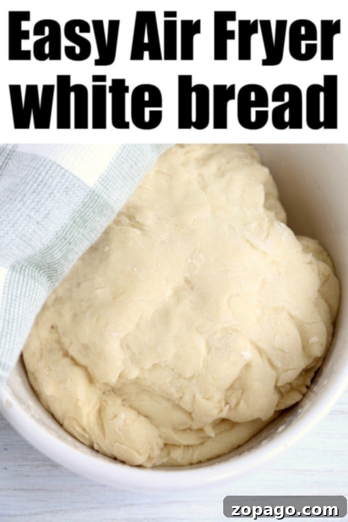 Air fryer white bread is easy to make with just 6 ingredients and very little kneading required. Perfectly fluffy white bread done in no time. Two mini loaves of air fryer bread baking inside an air fryer basket, achieving a beautiful golden crust.