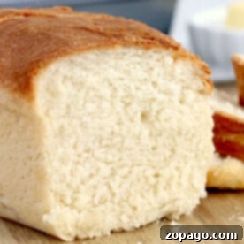 Close-up of a golden brown crusted loaf, its soft white interior revealing the magic of air fryer bread. Nestled on a wooden surface, it invites you to savor its perfect blend of texture and flavor.