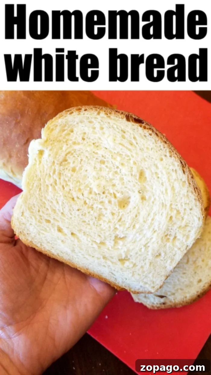 Best fluffy homemade white bread recipe you'll want to make over and over again! Easy sandwich bread you can make even if you've never baked bread before. A slice of fluffy homemade white bread, showcasing its soft, airy texture, next to a full loaf on a cutting board.