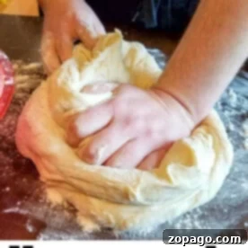 A person skillfully kneads dough on a floured surface, embodying the comforting art of baking homemade white bread.