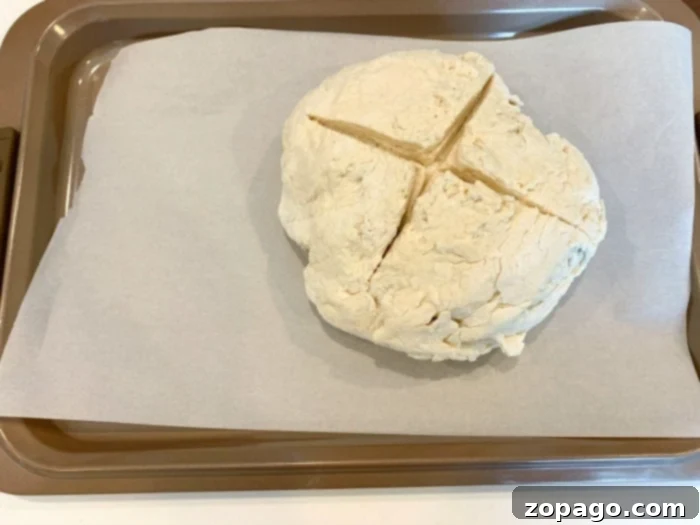 Easy 3 Ingredient Bread 5 Dough for no yeast bread being formed into a perfect round loaf on a floured surface.