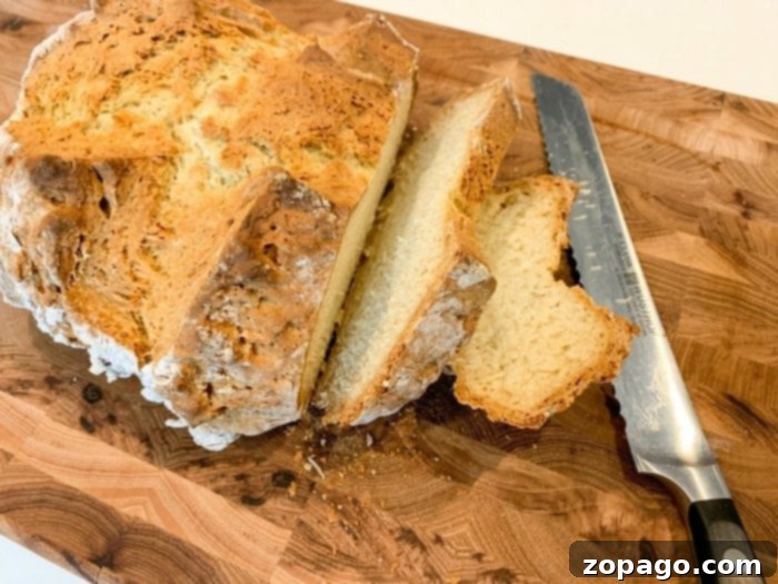 Easy 3 Ingredient Bread 7 Sliced Irish soda bread served beautifully on a wooden plate, ready to eat.