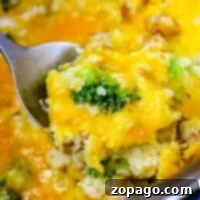 Close-up of a cheesy Instant Pot chicken broccoli and rice casserole being scooped with a spoon.