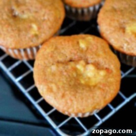 Close-up of freshly baked 4 ingredient banana bread muffins with a golden-brown top, cooling on a wire rack.