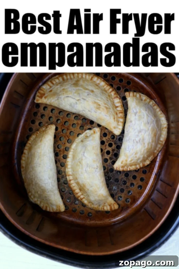 Crispy Air Fryer Empanadas 8 Four golden-brown air fryer empanadas resting in an air fryer basket, perfectly cooked.