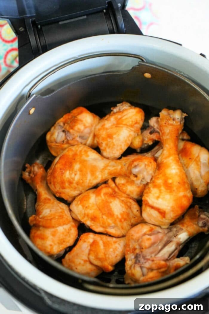 Ultimate Ninja Foodi Barbecue Drumsticks 8 Chicken drumsticks with a golden-brown crust resting in a Ninja Foodi air fryer basket, perfectly air-fried.