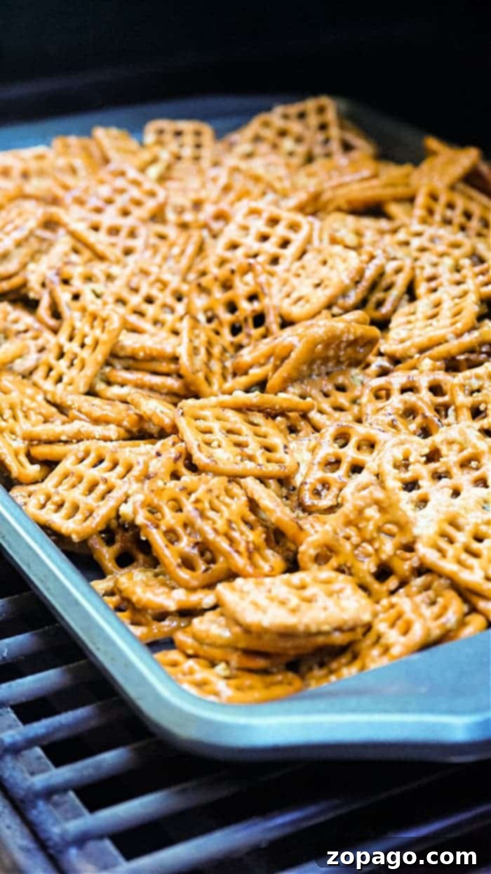 Close-up of Reese's Pretzel Bites cooling on a baking sheet, showing the melted chocolate and pretzel texture.