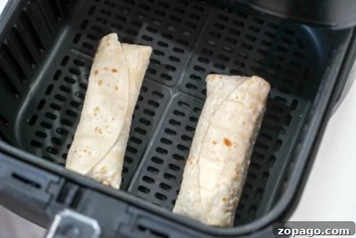 Crispy Air Fryer Frozen Burrito 4 Several air fryer frozen burritos arranged in the air fryer basket for even cooking