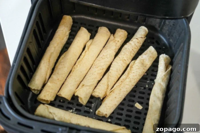 A close-up shot of frozen taquitos, still in their frosty state, before being placed into the air fryer for cooking.