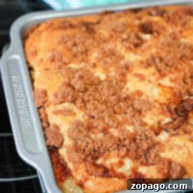 Effortless 3 Ingredient Dump Cake 7 A delightful 3 ingredient dump coffee cake with a crumbly topping, freshly baked in a metal pan on a cooling rack.