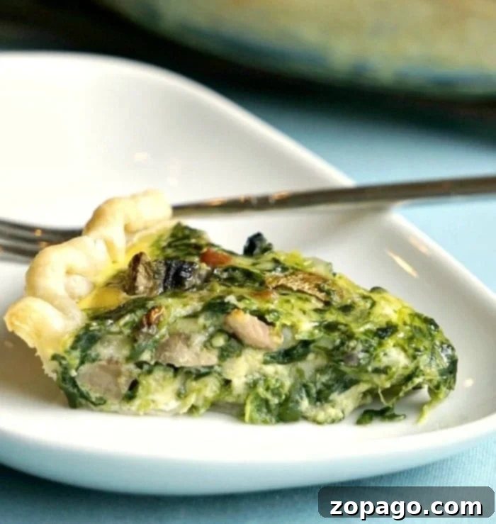 No-Fuss Spinach Quiche 4 A perfectly sliced piece of easy spinach quiche with visible mushrooms and a golden crust.