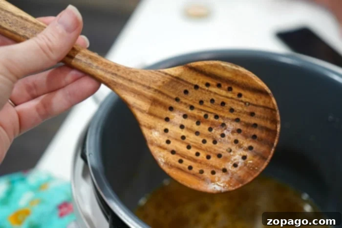 Perfect Instant Pot Mushrooms 7 A wooden slotted spoon, ideal for Instant Pot cooking